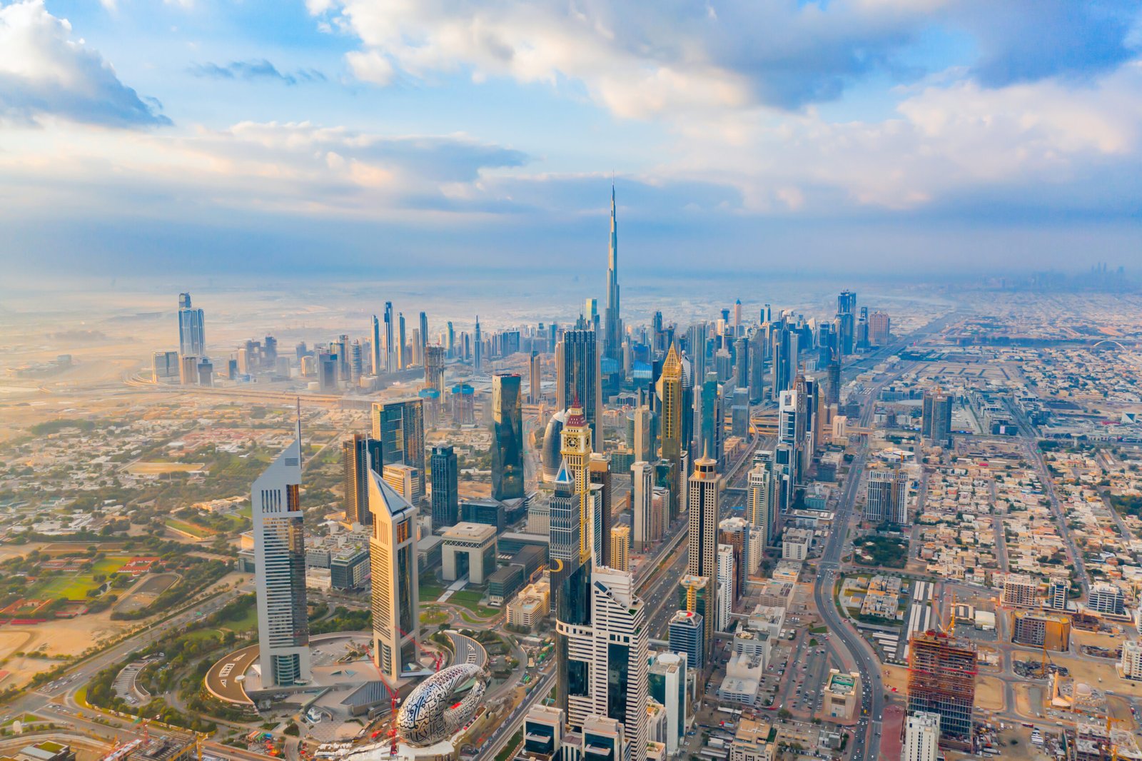 Aerial view of Burj Khalifa in Dubai Downtown skyline and highway, United Arab Emirates or UAE. Financial district and business area in smart urban city. Skyscraper and high-rise buildings at sunset.